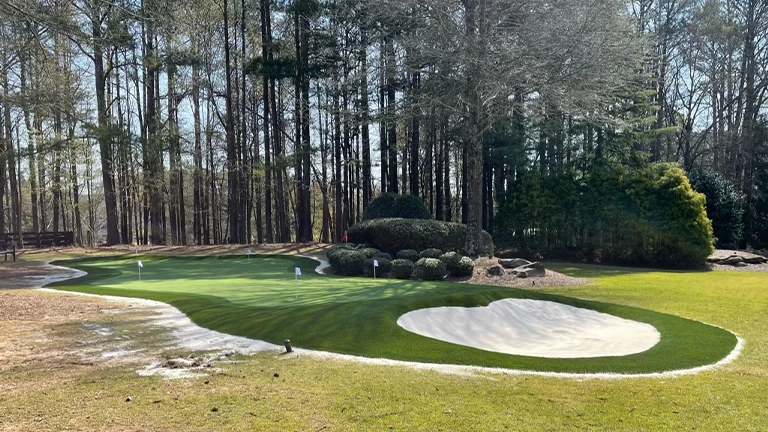 Professional putting green installation in a Memphis backyard, creating a personal golf practice area with high-quality synthetic grass.