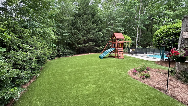 Expert artificial turf installation in a Memphis home, showcasing durable and low maintenance synthetic grass for residential landscaping.